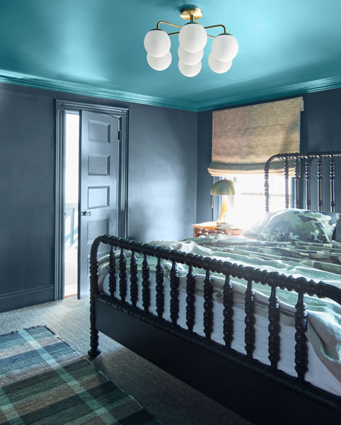 A bedroom with carved black bed frame.  The walls are painted in Gentleman's Gray and the ceiling and coving is painted in Naples Blue 2057-30.