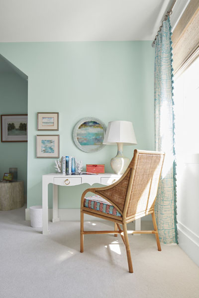 A dressing table vignette with teal and white patterned curtains and a white desk painted in Snow White 2112-70. The walls are painted in Spring Mint 2040-70.